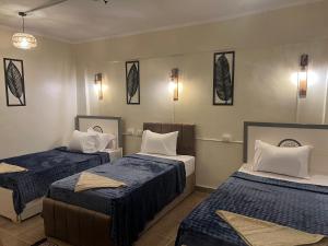 a room with two beds with blue and white sheets at Backpackers Room 3 in Naj‘ al Maḩaţţah