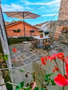 a table and chairs with an umbrella on a patio at Casa Bellavista in Montefegatesi