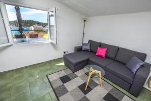 a living room with a couch and a window at Apartments Ercegovic in Rogoznica