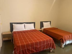 two beds sitting next to each other in a room at pousada recanto gerais in Carmo do Rio Claro