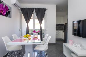 a kitchen and dining room with a table and chairs at Apartments Zdeslav in Rogoznica