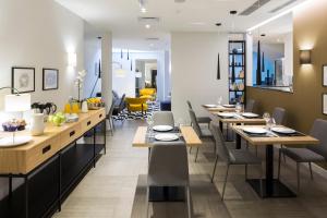 a dining room with long tables and chairs at Livris Hotel in Zagreb
