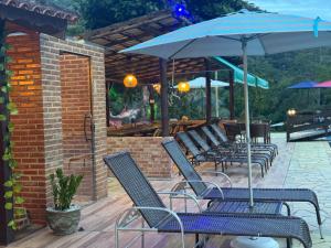 a row of chairs and an umbrella on a patio at Estação Serramar in Lumiar +270 photos