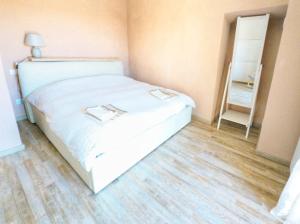 a bedroom with a white bed and a wooden floor at Casa Bellavista in Montefegatesi