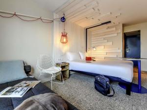 a hotel room with a bed and a couch at ibis styles La Rochelle Thalasso Chatelaillon in Châtelaillon-Plage +155 photos