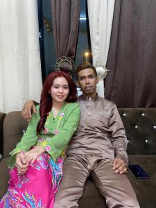 a man and a woman sitting on a couch at Apemen in Kuching