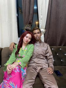 a man and a woman sitting on a couch at Apemen in Kuching