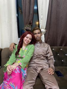 a man and a woman sitting on a couch at Apemen in Kuching