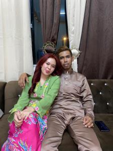 a man and a woman sitting on a couch at Apemen in Kuching