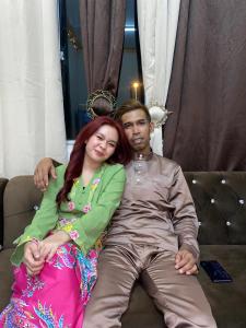 a man and a woman sitting on a couch at Apemen in Kuching