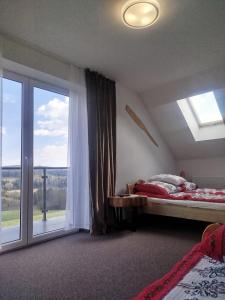 a bedroom with a bed and a large window at Gorczańska EKO-SFERA in Wola Piskulina