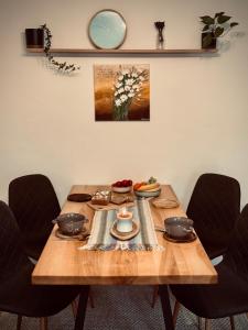 a wooden table with plates and utensils on it at Jarmočná Apartmán in Stará Ľubovňa +9 photos