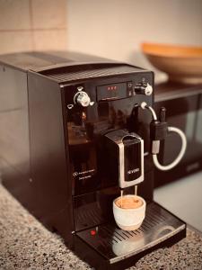 a coffee machine with a cup on a counter at Jarmočná Apartmán in Stará Ľubovňa