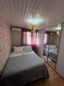 a bedroom with a large bed and a mirror at Casa Conforto & Lazer Foz do Iguaçu in Foz do Iguaçu
