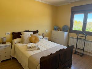 a bedroom with a large bed and two windows at Refugio y Calma in Chantada