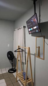 a room with a flat screen tv on top of a stand at Pousada São Paulo - Quartos com WC Exclusivo in Recife