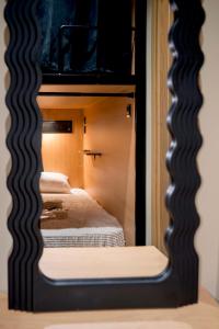 a mirror reflecting two beds in a room at Chania Capsule Stay in Chania
