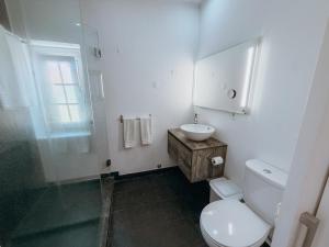 a white bathroom with a toilet and a sink at Villa Frescura do Mar by Casas de Setúbal in Setúbal