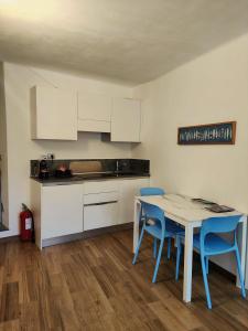 a kitchen with a table and two blue chairs at Casa Mafalda in Manarola