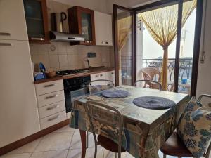 a kitchen with a table and chairs with a view at Cavalluccio Marino-Central-with Balcony by Gessica Holiday in Polignano a Mare