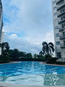 a large swimming pool between two tall buildings at MiCasa South Residences Cozy & Affordable Stay in Manila