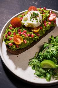 a plate with an egg on a piece of bread with a salad at Hotel Panamera in Tulum