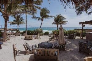a beach with chairs and umbrellas and the ocean at Hotel Panamera in Tulum
