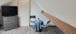 a room with a table and chairs and a tv at Studio Paisible in Nouzilly
