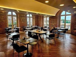 a restaurant with tables and chairs in a room with windows at Mercure Albi Rives du Tarn in Albi