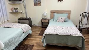 a bedroom with two beds and a table and a chair at MI HOGAR ES TUYO in Punta Arenas