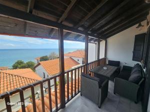 a balcony with a table and chairs and the ocean at PELION HORIZON houses in Agios Ioannis Pelio