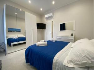 a bedroom with a blue bed and a tv at Halisa Casa Vacanze in Palermo