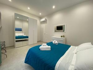 a bedroom with a blue bed with towels on it at Halisa Casa Vacanze in Palermo