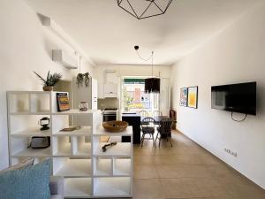 a living room with white shelves and a kitchen at Casa Melina - Pesaro Mare in Pesaro