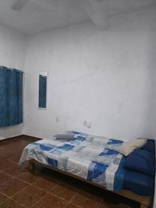 a bedroom with a bed with a blue and white blanket at Estudio Mar in Brisas de Zicatela