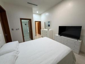 a bedroom with a bed and a flat screen tv at MayaVilla in Long Swamp