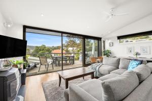 a living room with a couch and a table at Breakers Holiday House in Lorne