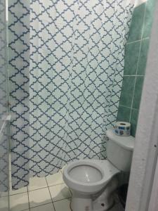 a bathroom with a toilet and a tiled wall at Estudio Mar in Brisas de Zicatela