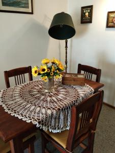 a table with a vase of yellow flowers on it at La perla depto in Mar del Plata