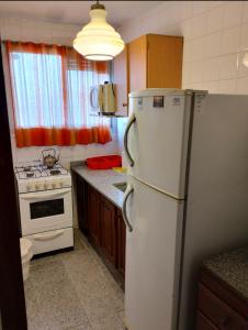 a kitchen with a white refrigerator and a stove at La perla depto in Mar del Plata