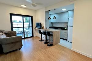 a kitchen with a bar and a couch in a room at APARTAMENTO PRÓXIMO AO CENTRo in Joinville