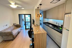a kitchen and living room with a couch and a table at APARTAMENTO PRÓXIMO AO CENTRo in Joinville