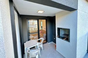 a living room with a table and chairs and a fireplace at APARTAMENTO PRÓXIMO AO CENTRo in Joinville