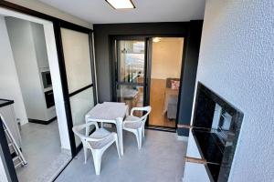 a room with a table and two chairs and a table at APARTAMENTO PRÓXIMO AO CENTRo in Joinville +6 photos
