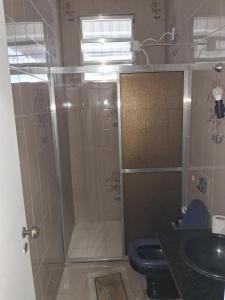 a bathroom with a shower and a toilet and a sink at Pousada Paula Lima I in Juiz de Fora
