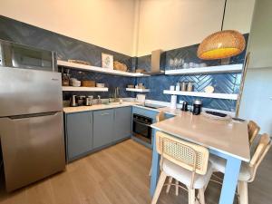 a kitchen with a table and a stainless steel refrigerator at Lantana Sea La Vie - by ZenBreak in Saint James