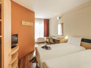 a hotel room with two beds and a television at ibis Bamberg Altstadt in Bamberg +45 photos