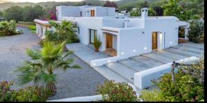a white house with palm trees in front of it at Morna valley in Sant Carles de Peralta