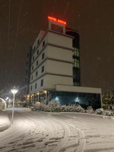 a building with a sign on top of it in the snow at Hotel Ascua in Tirana