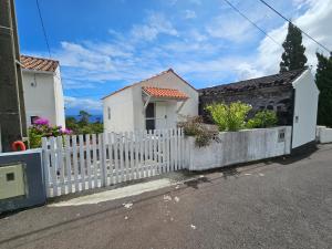a white fence in front of a house at T1 com Vista Mar em Sao Roque do Pico Residências Requinte in São Roque do Pico